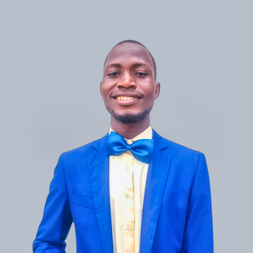 Portrait photo of Oluwashola Busari, smiling, wearing a blue jacket against a neutral background